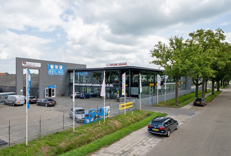 Bedrijfscomplex met glazen showroom verdeeld over twee bouwlagen en bedrijfs- en verhard buitenterrein rondom