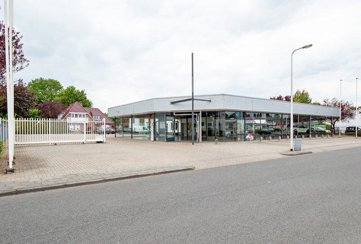 Showroom aan de weg met wit hek voor verhard buitenterrein