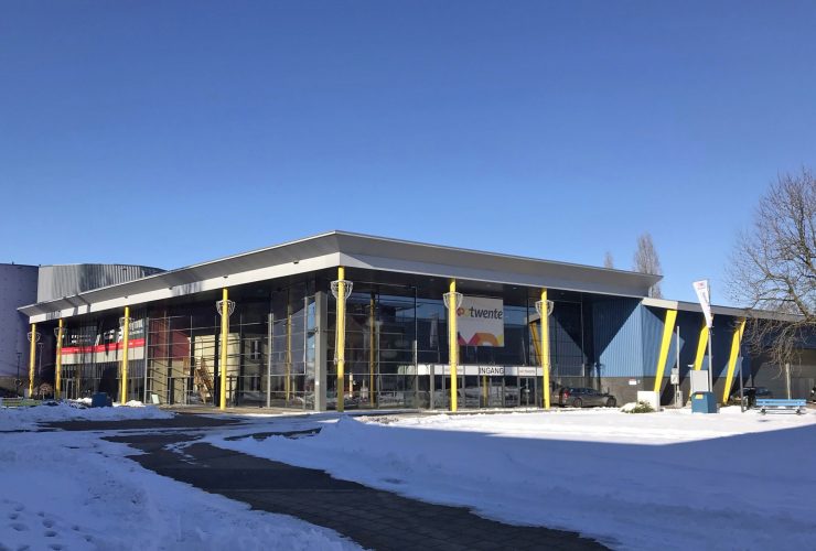 Bedrijfshal Colosseum 70 in Enschede met gele pilaren met sneeuw op voorgrond