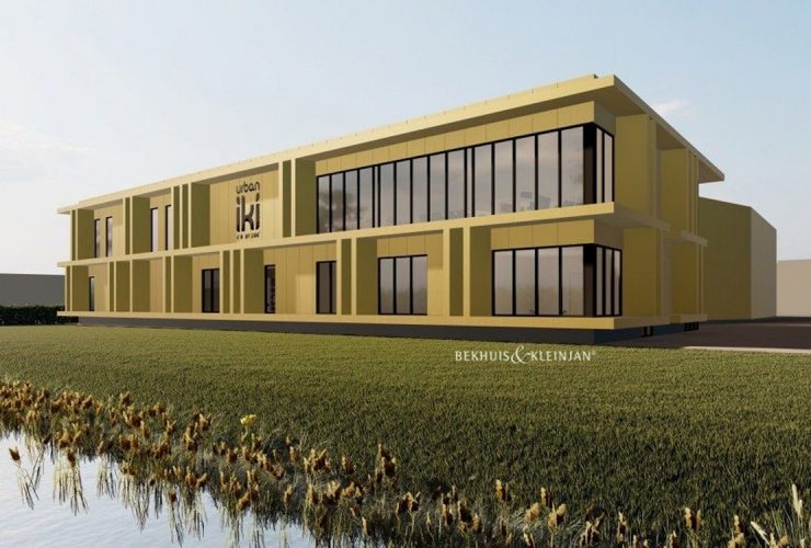 Modern, goudkleurig bedrijfspand met rondom gras en langs het water in Nijverdal